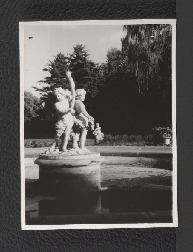 2 fotografie czarno-białe przedstawiające rzeźby figuratywne kupidynów w centralnej części fontanny , skan 1