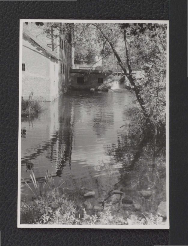 2 fotografie czarno-białe przedstawiające fragmenty zabudowań oraz miejscowy zbiornik wodny, skan 1
