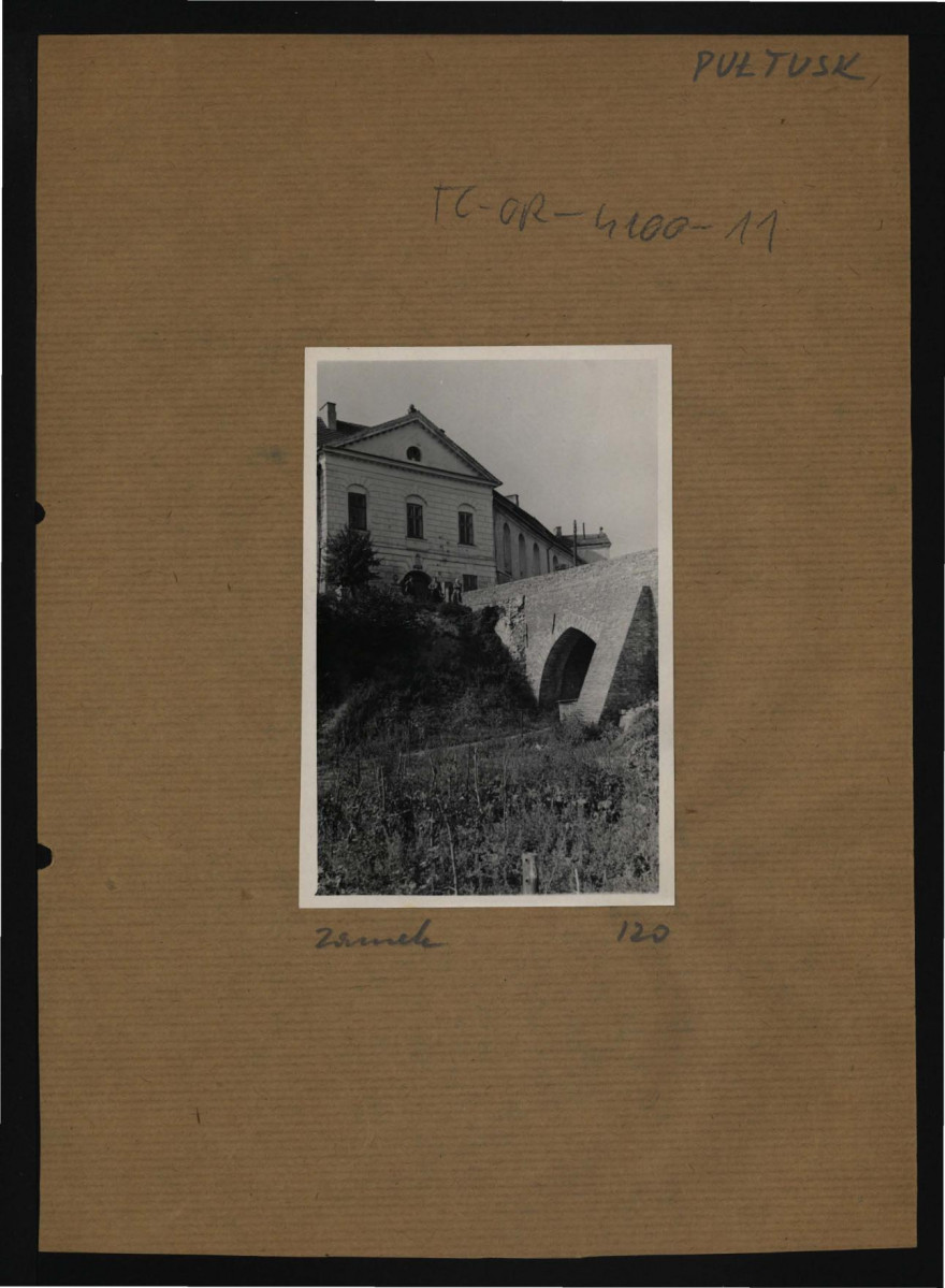 fotografia czarno-biała przedstawiająca fragment miejscowego zamku od strony fosy, skan 1
