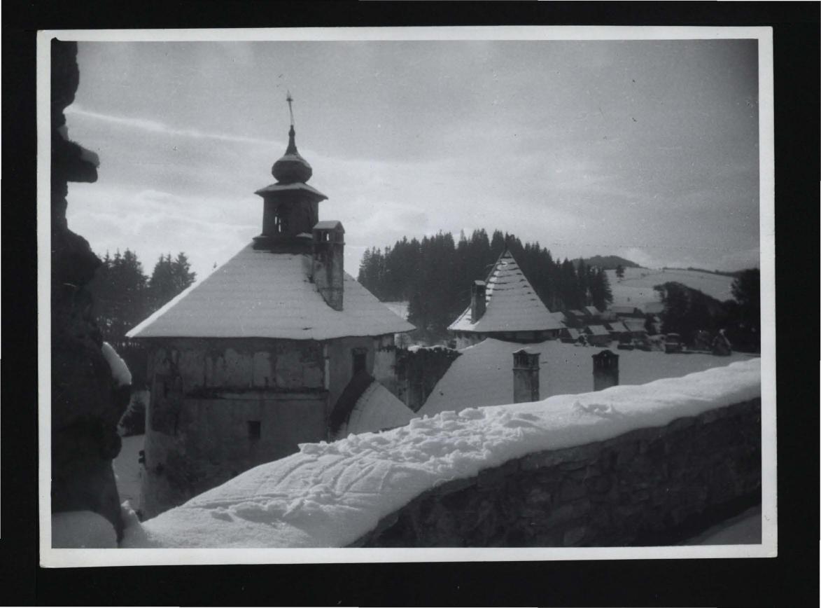 2 fotografie czarno-białe przedstawiające widok z zamkowych murów na baszty usytuowane w południowej części budowli, skan 1