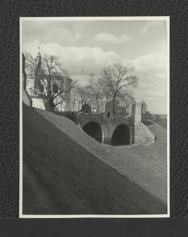 fotografia czarno-biała ukazująca dawne zabudowania zamkowe oraz kościół pw. Przemienienia Pańskiego, skan 1