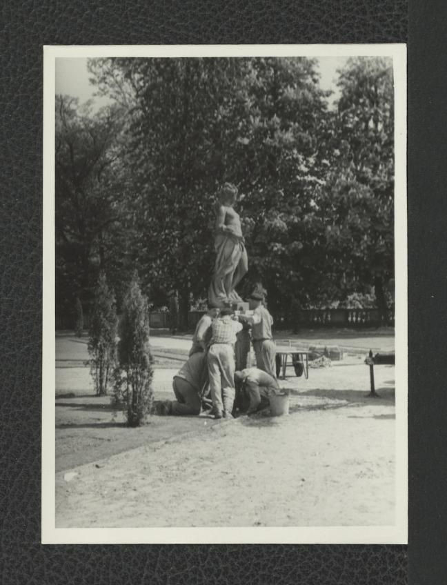 fotografia czarno-biała przedstawiająca stawianie rzeźby w miejscowym ogrodzie, skan 1