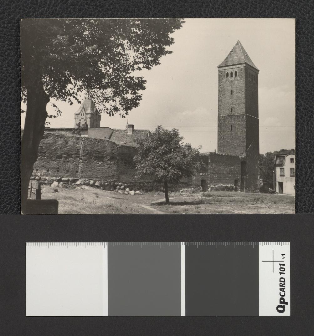 fotografia czarno-biała w formie pocztówki; przedstawia mury i baszty obronne z XIII w., skan 1