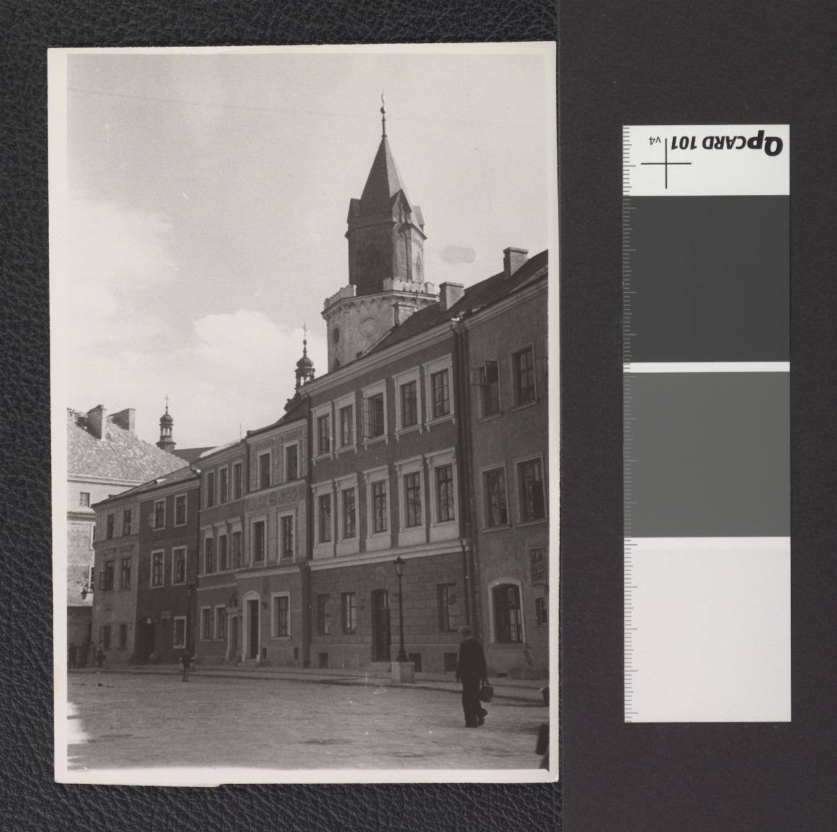 elewacje frontowe kamienic m. in. przy ul. Rynek 17 (kamienica Wieniawskich) i ul. Rynek 16 (tzw. kamienica Muzyków) z widoczną ponad ich dachami Bramą Trynitarską, skan 1