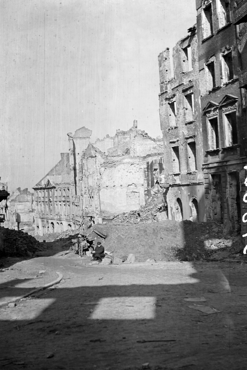 Zabudowa miejska. Ul. Freta i róg Mostowej. Ruiny i gruzowisko. Siedzący mieszkaniec przy gruzowisku., skan 1