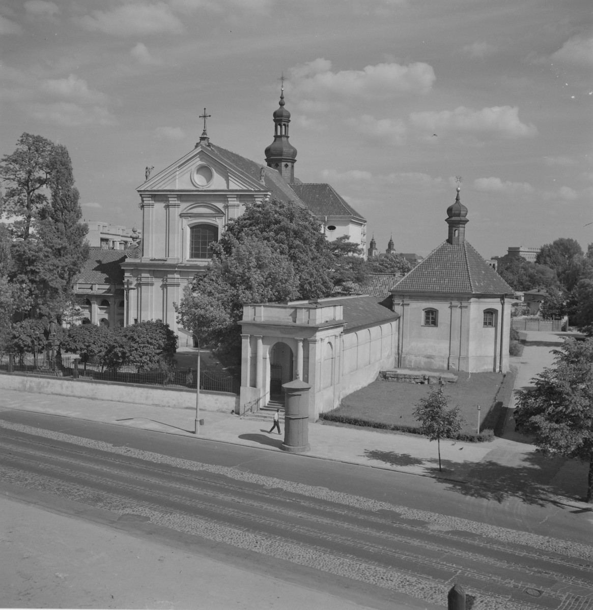 Kościół św. Antoniego. Po odbudowie. Główna bryła świątyni ma charakter barokowy i jest jednonawowa, z wyraźnie wyeksponowaną fasadą frontową ujętą pilastrami. Fasada jest dwukondygnacyjna i podzielona na trzy osie. W osi środkowej znajduje się duże okno zamknięte półkoliście, ujęte dekoracyjnym obramieniem z łukowym naczółkiem. Powyżej, w polu trójkątnego szczytu, umieszczono okrągły otwór okienny. Szczyt fasady wieńczy krzyż, a na jego krawędziach ustawione są figury rzeźbiarskie. Podziały pionowe tworzą pilastry, a kondygnacje oddzielone są profilowanymi gzymsami. W wyniku powojennej rozbudowy powstał także wyraźnie wydzielony zespół od strony ulicy. Po prawej stronie zespołu znajduje się dodatkowy budynek o zwartej bryle, na planie zbliżonym do kwadratu, przykryty wysokim dachem czterospadowym zwieńczonym niewielką latarnią z cebulastym hełmem i krzyżem., skan 1