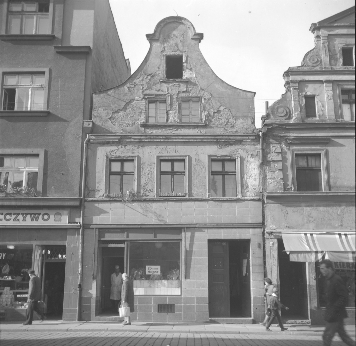 Zabudowa miejska. Elewacja frontowa kamienicy. Renesansowy szczyt. Mieszkańcy. Sklep mięsny., skan 1