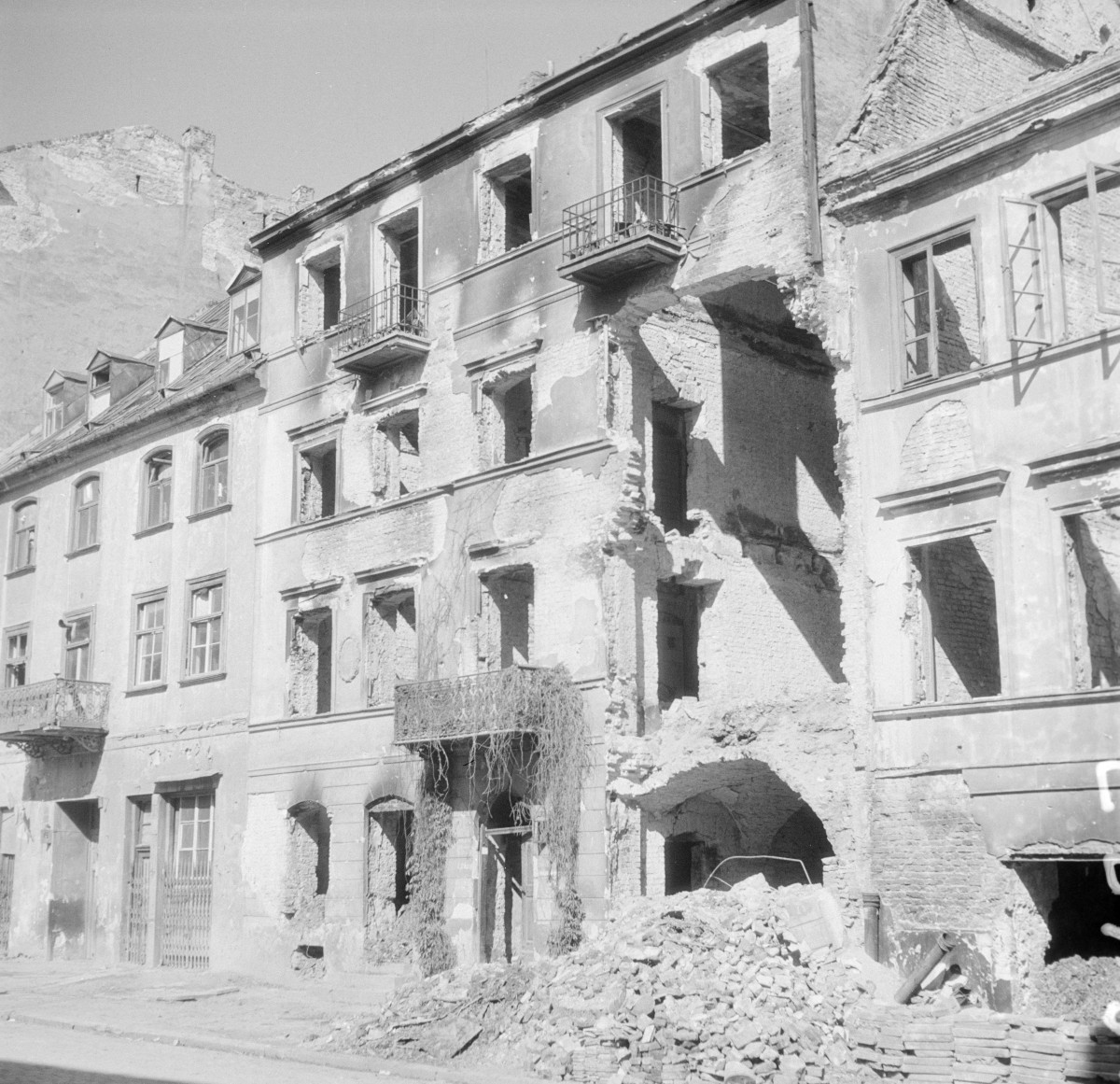 Ruiny kamienicy. Zniszczona elewacja frontowa, dach mansardowy. Widok od strony ulicy., skan 1