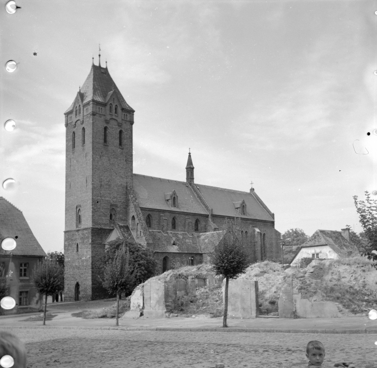 Kościół św. Mikołaja - widok ogólny. Wieża w kształcie kwadratu. Elewacja boczna z przyporami., skan 1