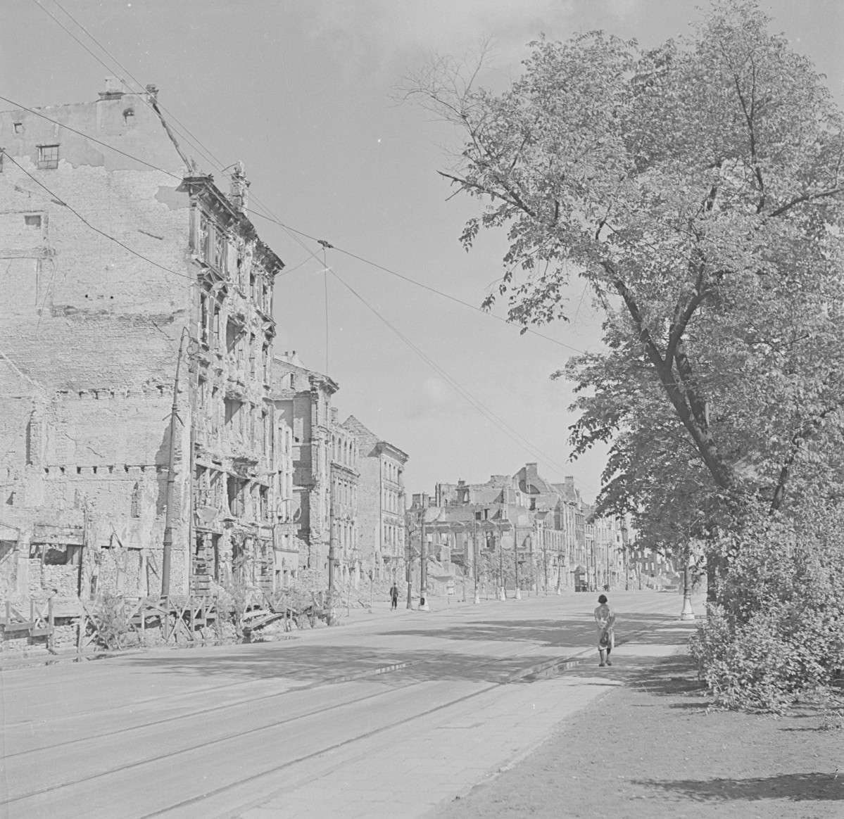 Zniszczone kamienice w kierunku placu Zamkowego Ulica z widocznymi torami tramwajowymi. , skan 1