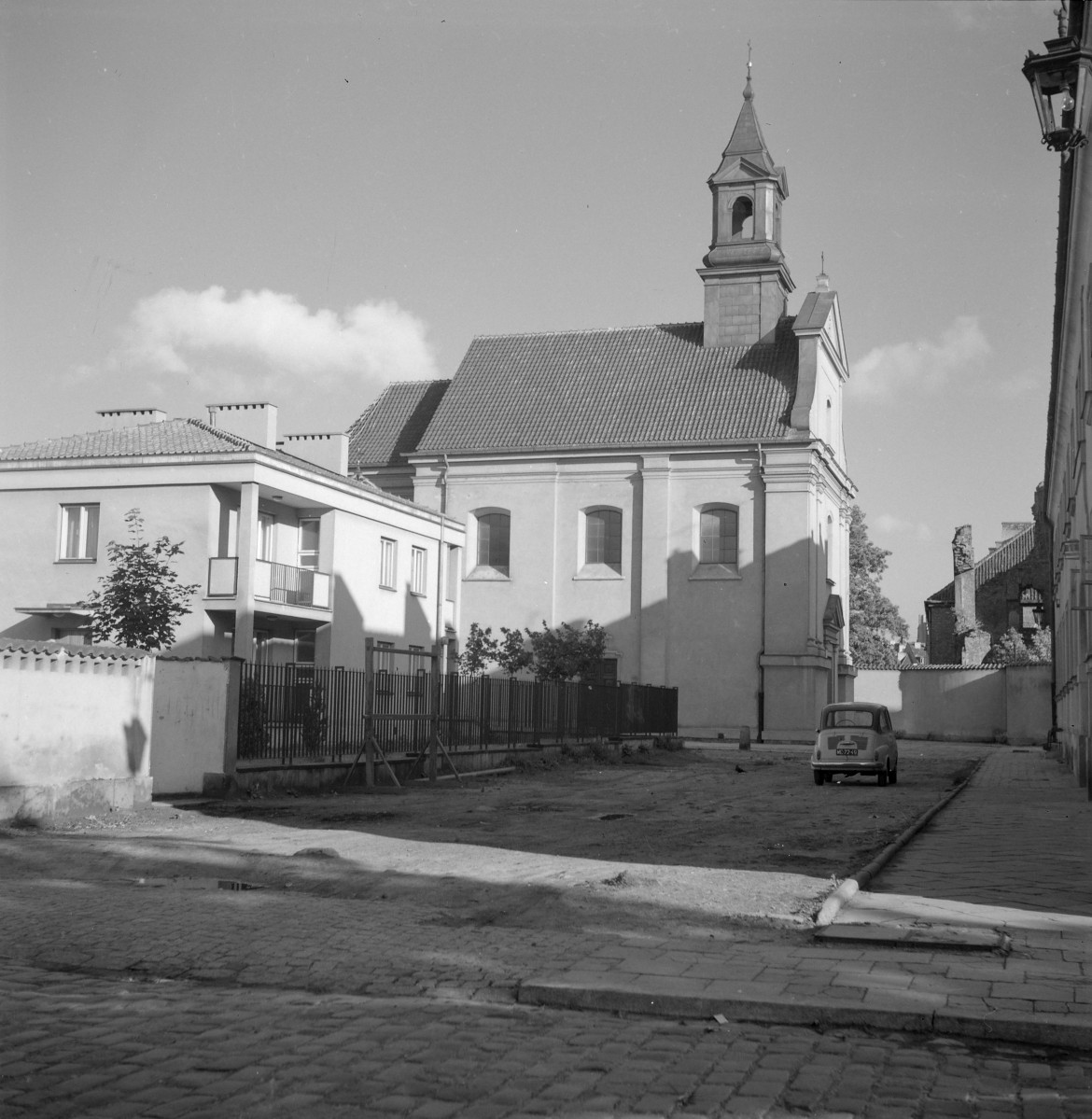 Kościół św. Benona. Po odbudowie. Elewacje są otynkowane i gładkie, a ich podziały architektoniczne zostały wyraźnie uporządkowane. Najbardziej charakterystycznym elementem jest smukła sygnaturka z hełmem, górująca nad nawą. , skan 1