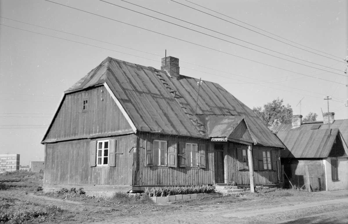 Zabudowa drewniana. Dom z dachem naczółkowym. Elewacja szalowana deskami. Okna z drewnianymi okiennicami., skan 1