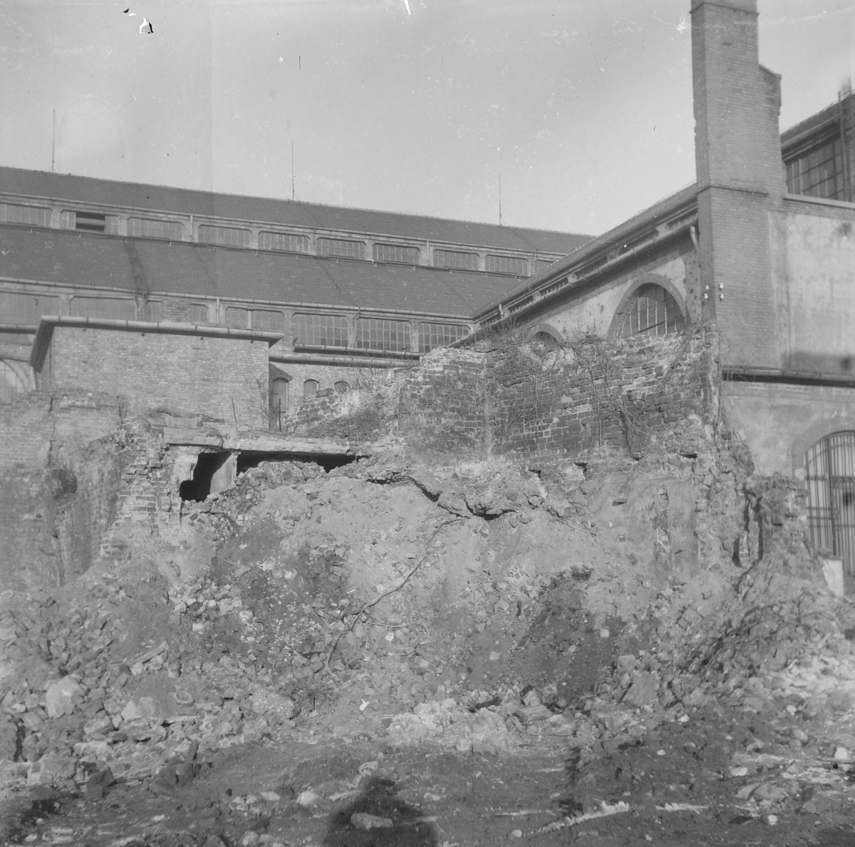 Zniszczone budynki hali targowej. Fragmenty elewacji i dachu oraz resztki murów miejskich. , skan 1
