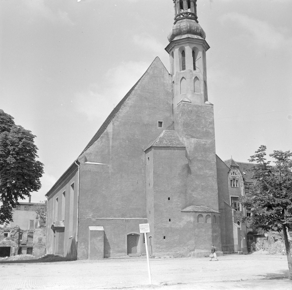 Kościół św. Barbary. Do korpusu przylega masywna, czworoboczna wieża, przechodząca wyżej w ośmioboczną partię z otworami dzwonowymi zamkniętymi łukiem. Wieżę wieńczy barokowy hełm o cebulastej formie z latarnią. Przy prezbiterialnej części świątyni widoczna jest niewielka, wieloboczna przybudówka – prawdopodobnie zakrystia – nakryta osobnym, niskim dachem. U jej podstawy widać małe, półkoliście zamknięte wnęki okienne. Całość sprawia wrażenie budowli wielokrotnie przekształcanej, w której pierwotna średniowieczna struktura została uproszczona i otynkowana, a w okresie nowożytnym uzupełniona o barokowe zwieńczenie wieży., skan 1