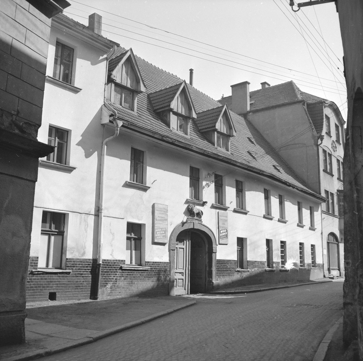Zabudowa miejska. Barokowa kamienica. Dach kalenicowy. Barokowy portal, gładki koszowy, Nad portalem wypukłorzeźba lwa., skan 1