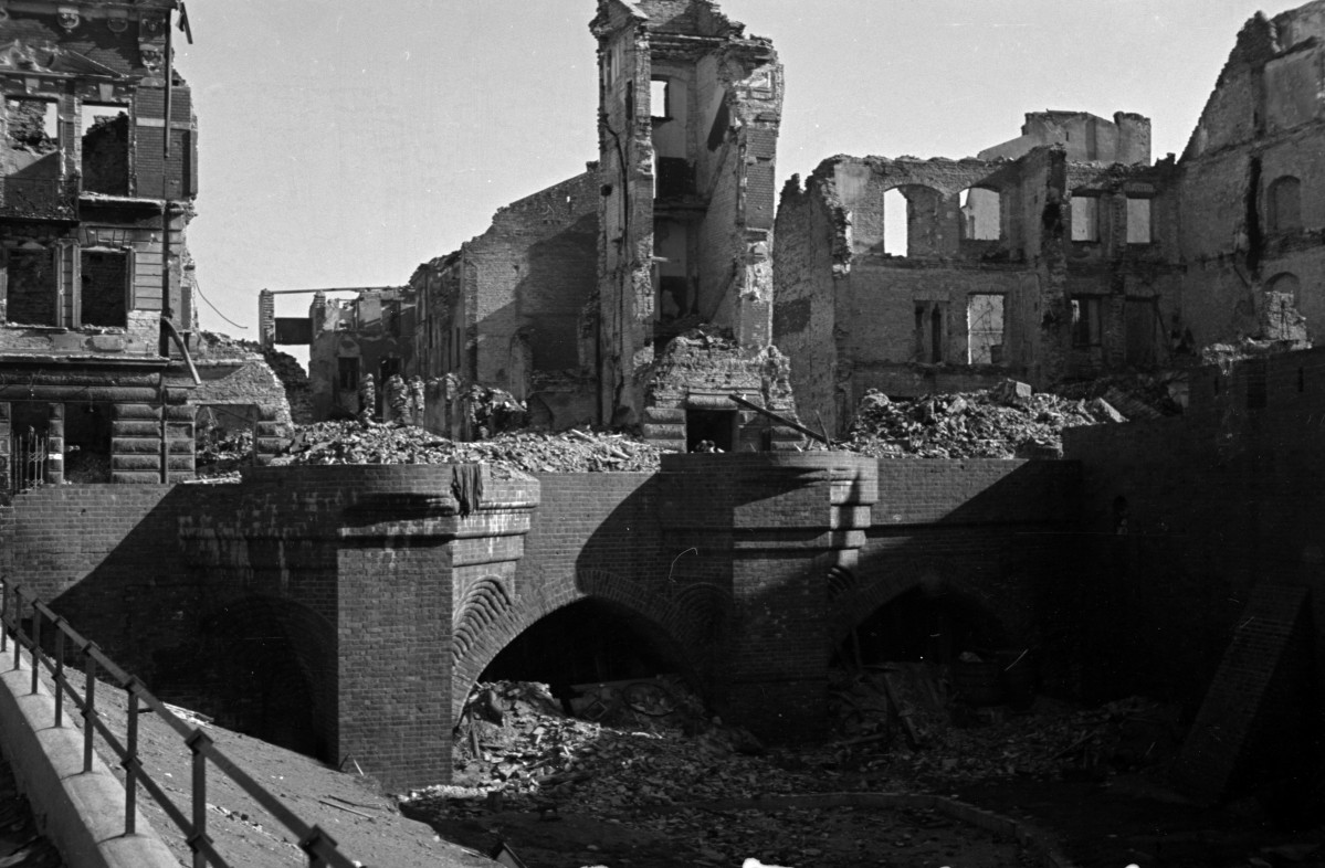 Zniszczona zabudowa miejska w okolicy mostka przy barbakanie. Ruiny kamienic.
, skan 1