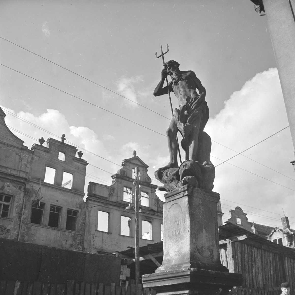 Fontanna z barokowym posągiem Neptuna z połowy XVIII w, na drugim planie zniszczone kamienice., skan 1