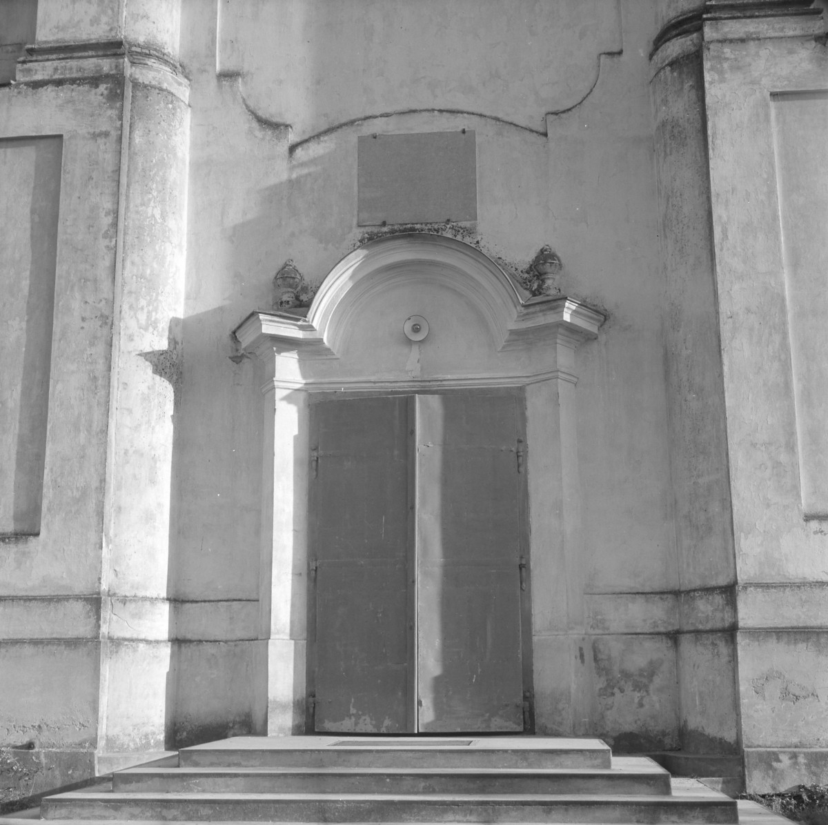 Kościół św. Józefa Oblubieńca i św. Antoniego z Padwy - Portal zachodni zwieńczony łukiem. Barokowy gzyms nad drzwiami.  Dekoracje boczne w postaci niewielkiej woluty., skan 1