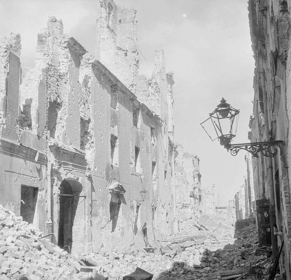 Zniszczony kościół pw. św. Marcina. Ruiny elewacji frontowej. Ulica z gruzowiskiem., skan 1