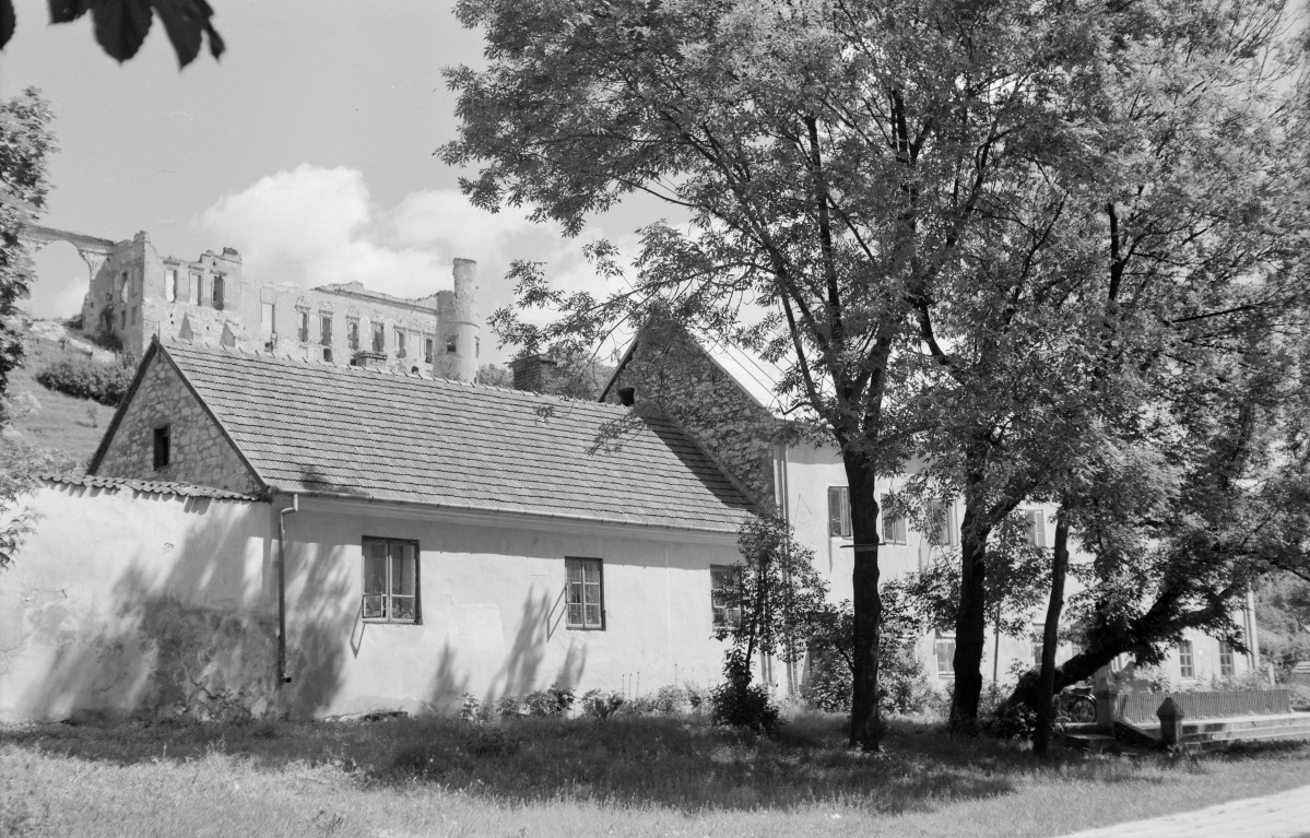 Kościół św. Stanisława Biskupa i Męczennika i św. Małgorzaty - elewacja plebani. Powyżej fragment ruin zamku., skan 1