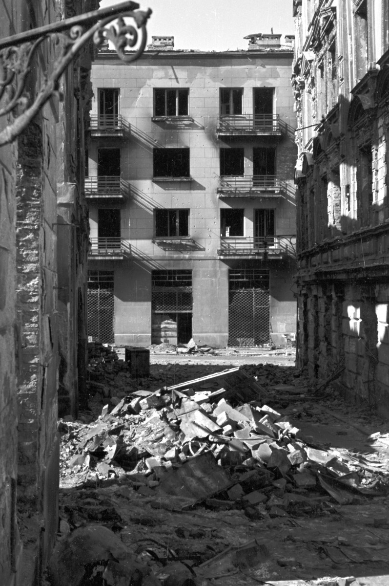 Ruiny zabudowy Starego Miasta z widokiem na rynek. Fragmenty kamienic w odbudowie. Widok w kierunku ul. Podwale., skan 1