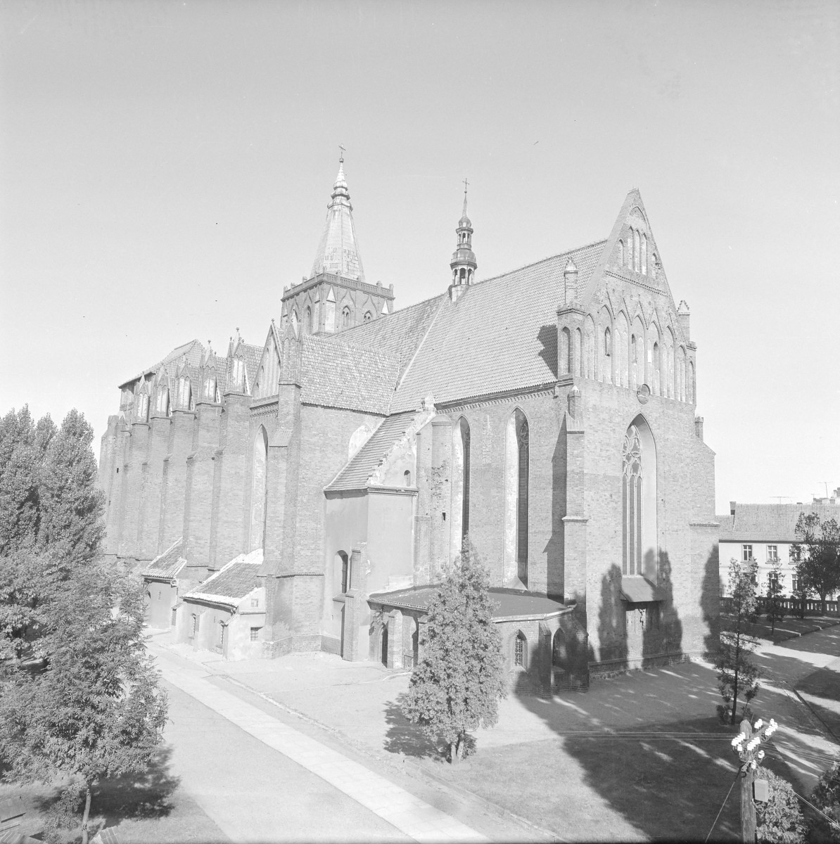 Kościół Wniebowzięcia Najświętszej Maryi Panny - widok ogólny. Elewacja boczna oraz frontowa. Widoczne przypory oraz liczne okna w stylu maswerk. Pinakle na zwieńczeniach skarp. , skan 1