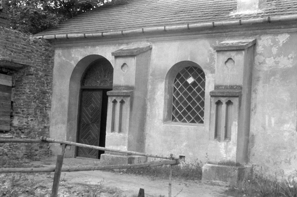 klasztor kanoników regularnych - kościół pw. Zwiastowania Najświętszej Marii Panny - elewacja - fragment portalem i przyporami, skan 1
