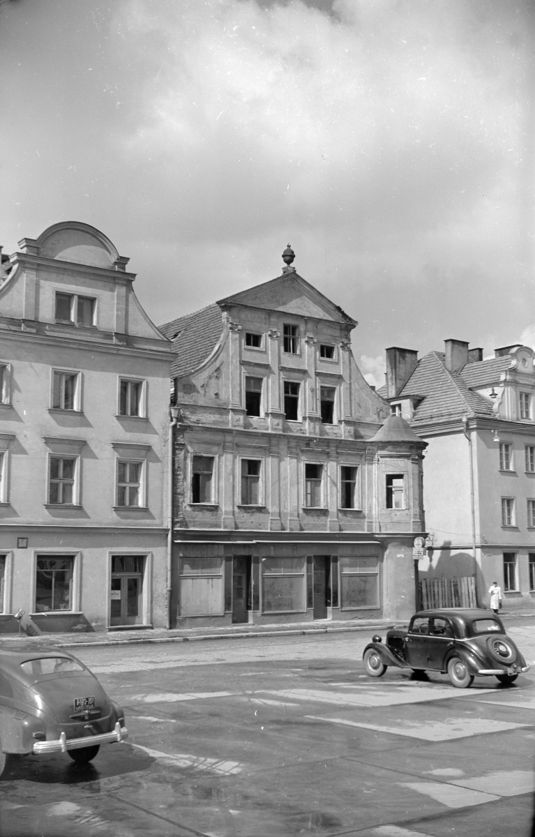 Rynek - pierzeja. Elewacje frontowe kamienic. Renesansowe szczyty budynków. Po prawej stronie na rynku zaparkowany Mercedes-Benz W136., skan 1