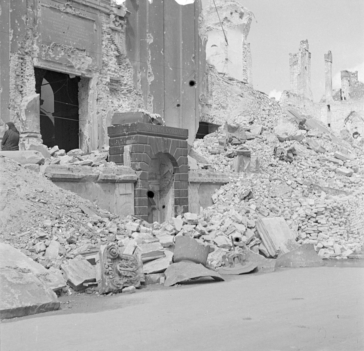 Bazylika św. Krzyża. Zniszczenia elewacji głównego wejścia. Obok widoczne gruzowisko Sali Czarnowskiego Uniwersytetu Warszawskiego., skan 1