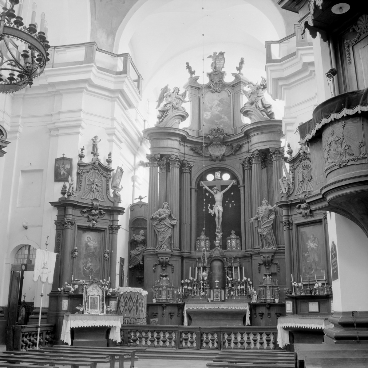 Kościół św. Józefa Oblubieńca i św. Antoniego z Padwy - prezbiterium z ołtarzem głównym. Wysokie filary. Centralnie umieszczony krucyfiks w otoczeniu figur świętych. Po prawej stronie ambona z baldachimem., skan 1