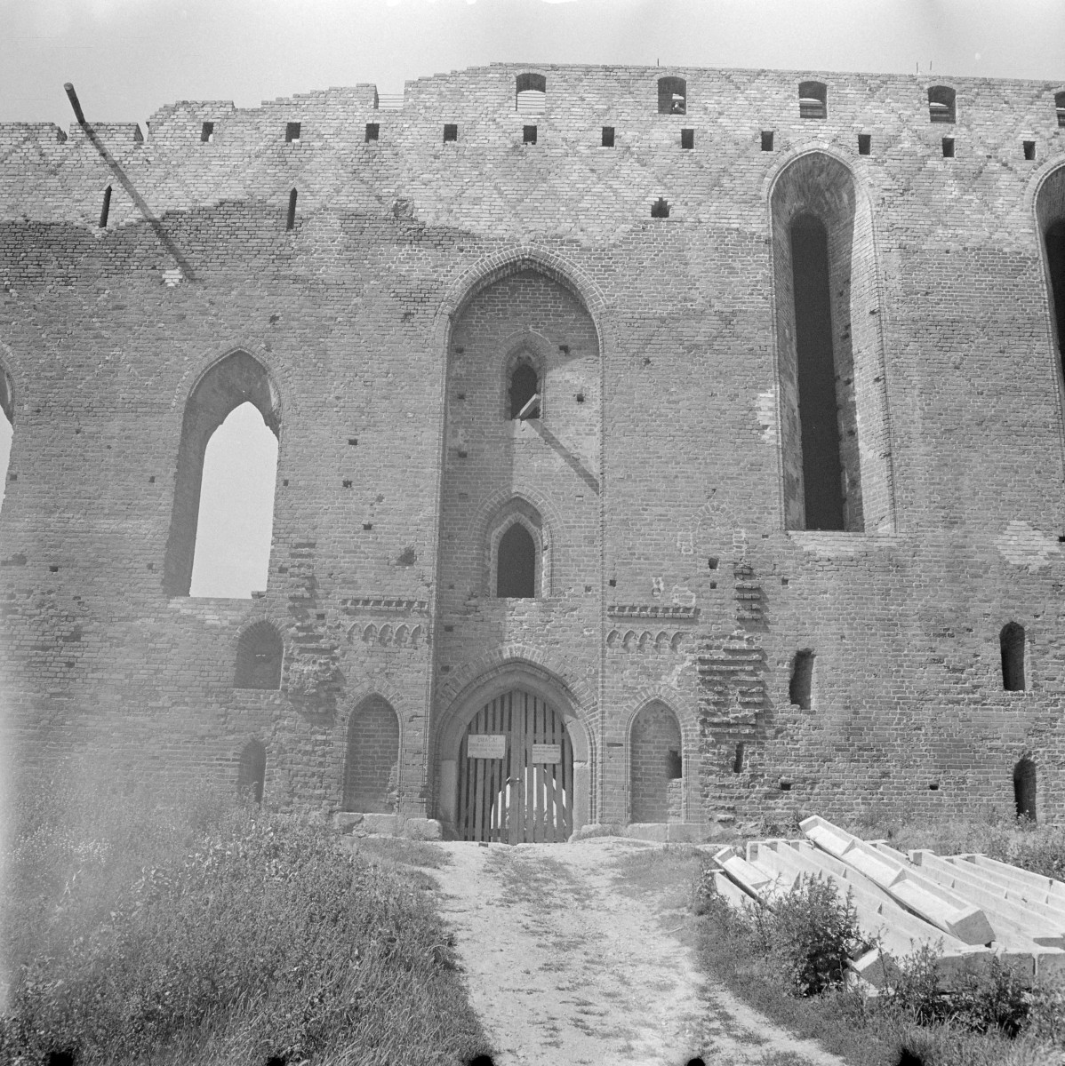 zamek krzyżacki - ruina - elewacja frontowa - fragment z portalem oraz koroną muru po odbudowie, skan 1