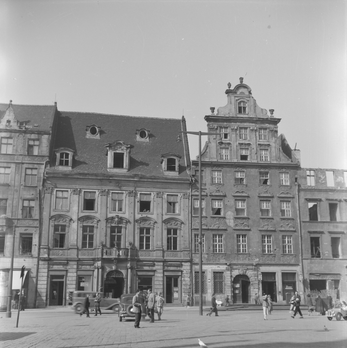 Fragment pierzei starego miasta. Kamienice patrycjuszowskie. Renesansowe i manieryczne szczyty - schodkowe, wolutowe. Wąska fasada z wysokimi parterami. Widoczna brama przejazdowa na podwórze. Elewacje zdobione sgraffitem. Mieszkańcy., skan 1