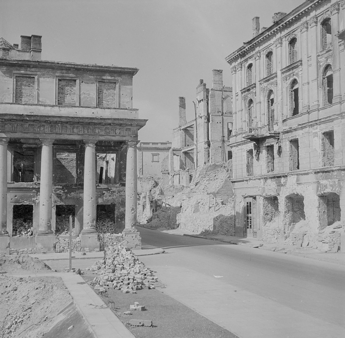 Widok na prawe skrzydło pałacu prymasowskiego i kamienice u wylotu ulicy. Zniszczenia. Ulica uprzątnięta z gruzowiska., skan 1