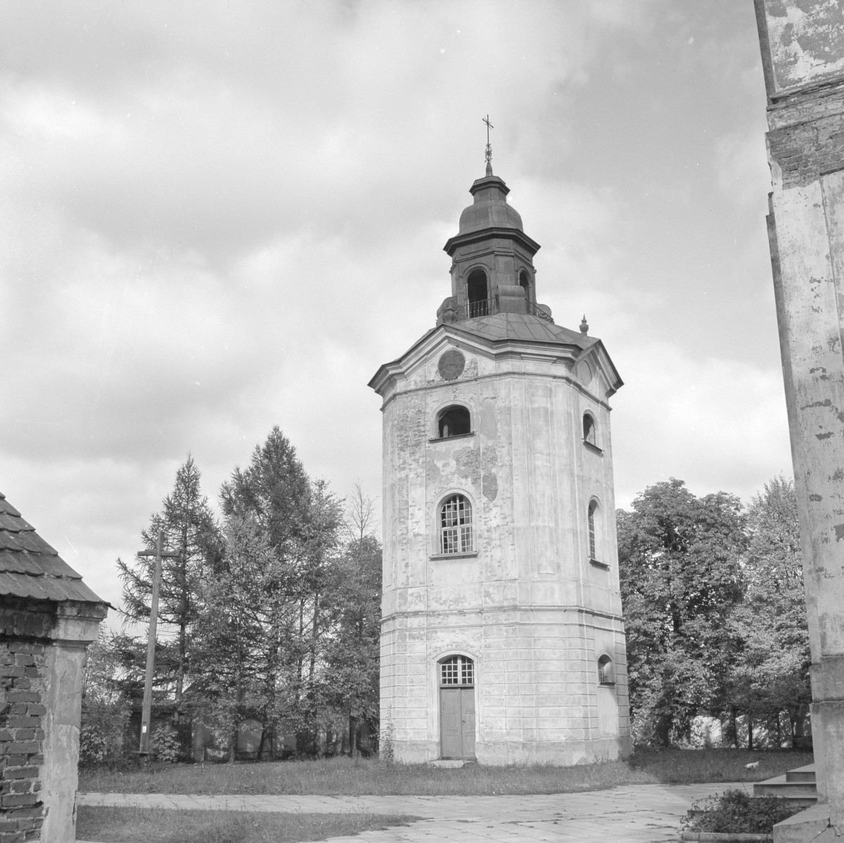 Kościół św. Józefa Oblubieńca i św. Antoniego z Padwy - dzwonnica kościelna. Lekko ścięte naroża w górnej części. Elewacje podzielone pilastrami w narożach, które podkreślają wertykalizm. Prostokątne drzwi z prostą opaską. Zwieńczenie to barokowy hełm ze smukłą latarnią. , skan 1