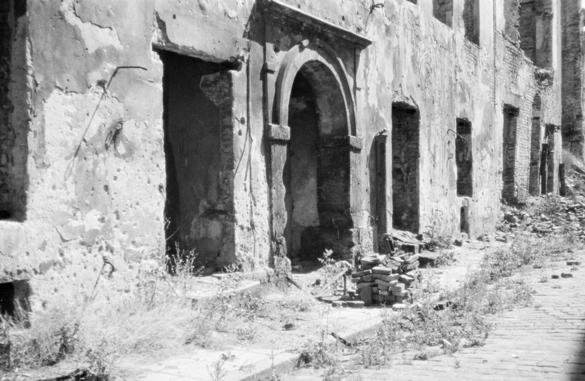 Zniszczona elewacja kamienicy z portalem., skan 1