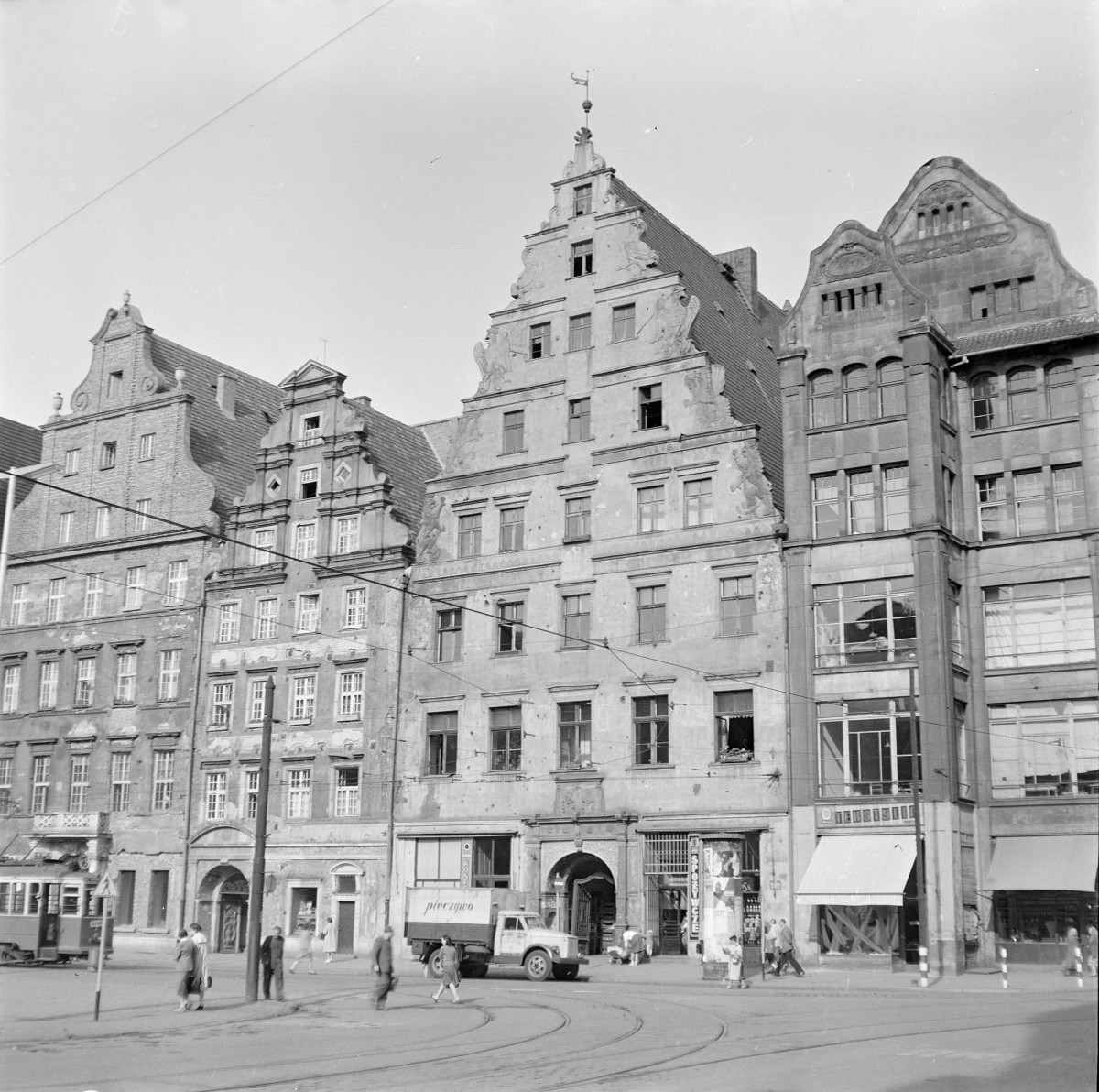 Fragment pierzei starego miasta. Kamienice patrycjuszowskie. Renesansowe i manieryczne szczyty - schodkowe, wolutowe. Wąska fasada z wysokimi parterami. Widoczna brama przejazdowa na podwórze. Elewacje zdobione sgraffitem. Mieszkańcy., skan 1