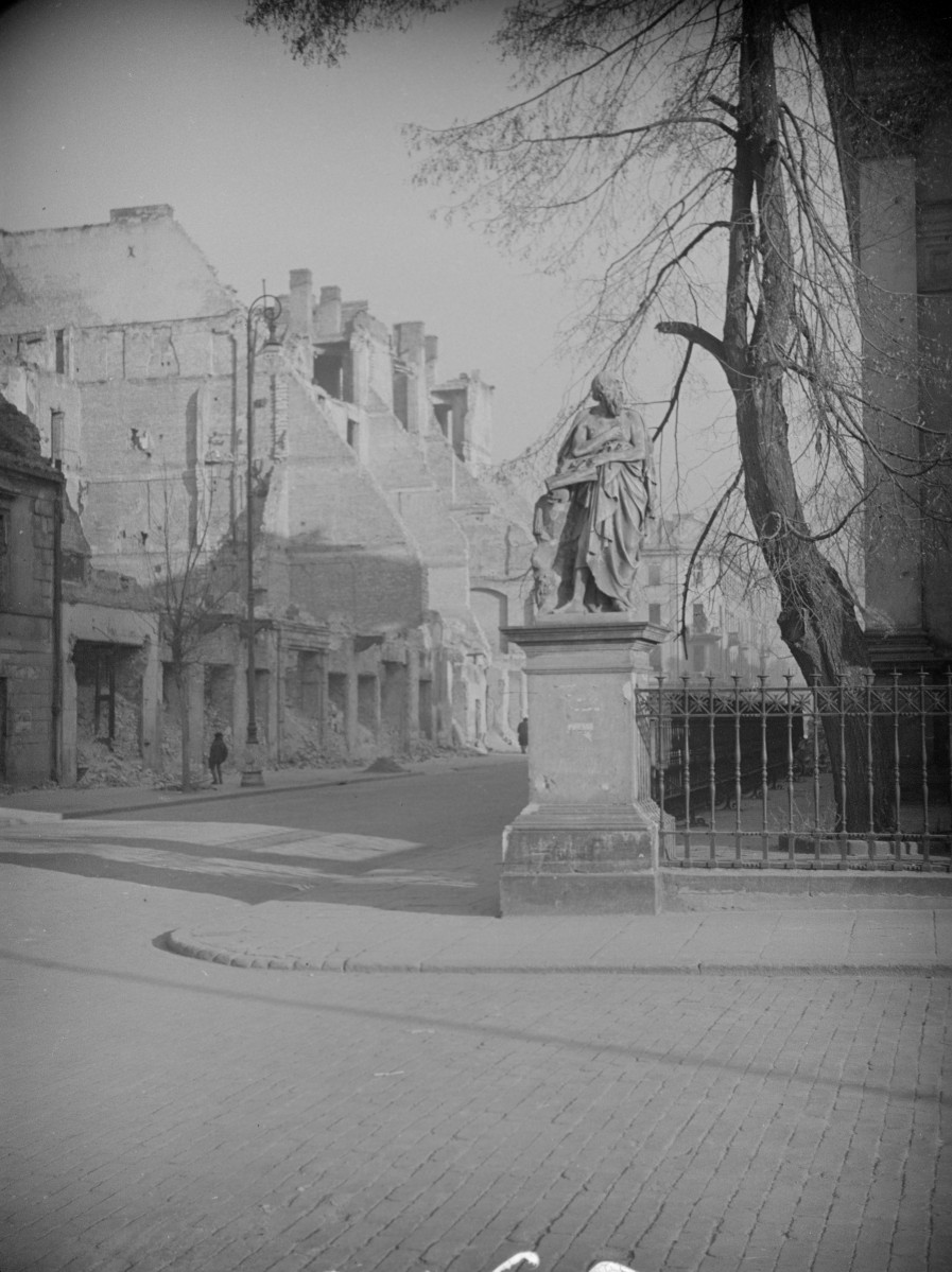 Zniszczona zabudowa miejska wzdłuż ulicy. rzeźba w narożniku ogrodzenia kościoła św. Boromeusza., skan 1