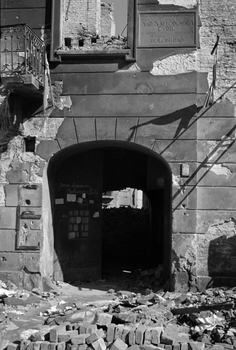 Kamienica Macieja Łyszkiewicza - zniszczona elewacja frontowa z widoczną bramą. Powyżej tablica z 1933 upamiętniająca odkrycie polonu u radu przez Marię Skłodowską Curie., skan 1