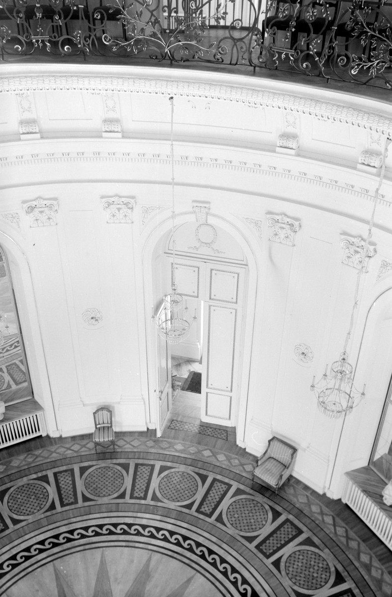 Palac - wnętrze: salon okrągły zw. biały. Meble i widoczne pilastry. Dekor., skan 1