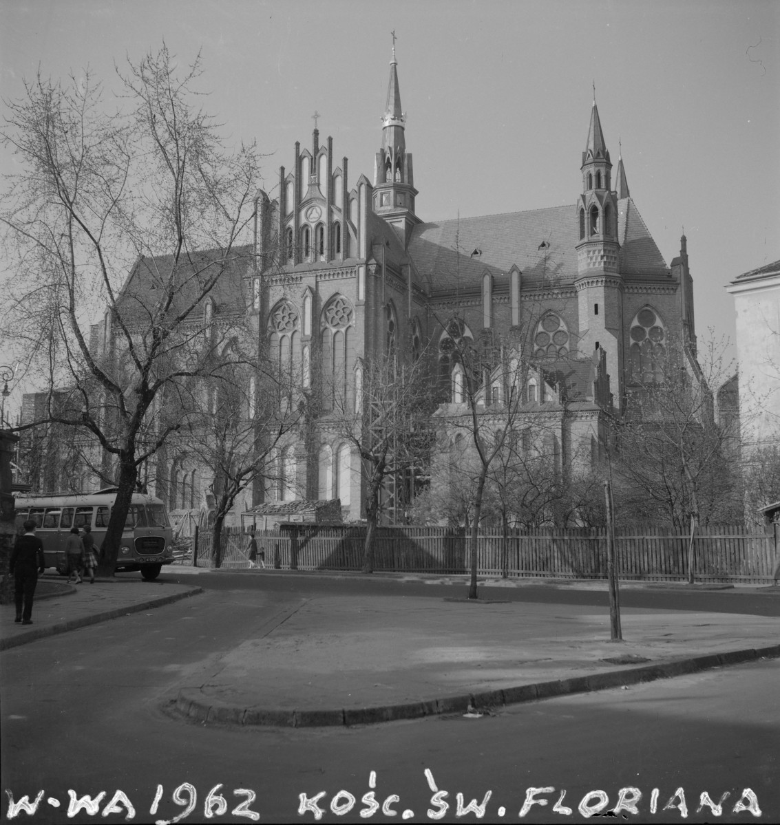 Kościół św. Floriana. Strzeliste wieże i smukłe hełmy, które nadają bryle lekkość i silny akcent pionowy. Widoczna jest rozbudowana, wieloczłonowa masa budowli: wysoka nawa główna, niższe partie boczne oraz wydzielone elementy wieżowe i szczytowe. Ostrołukowych otworów, wysokich blend i okien o maswerkowych podziałach. Szczególnie dobrze widać duże okna z dekoracją rozetową i trójlistną, które wzmacniają gotycki charakter świątyni. Szczyt fasadowy złożony z szeregu smukłych, sterczynowych pionów. , skan 1