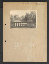 fotografia czarno-biała przedstawiająca fragment ogrodzenia wokół kompleksu pałacowego, bramę i część elewacji frontowej , skan 1