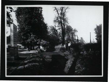 fotografia czarno-biała przedstawiająca mostek nad fosą przy miejscowej posesji, skan 1