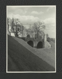 fotografia czarno-biała ukazująca dawne zabudowania zamkowe oraz kościół pw. Przemienienia Pańskiego, skan 1