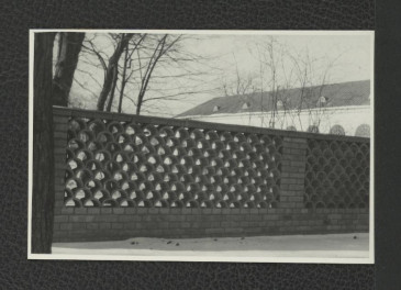 fotografia czarno-biała przedstawiająca fragment ogrodzenia oraz oranżerii, skan 1