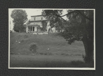 fotografia czarno-biała przedstawiająca fragment elewacji miejscowego pałacu z widocznym tarasem balkonowym, skan 1