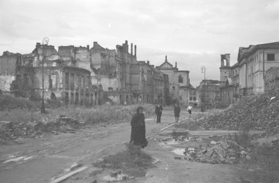 Widok od strony ul. Długiej. Skrzyżowanie z ul. Kilińskiego. Po prawej stronie widoczny zniszczony budynek Archiwum Główne Akt Dawnych. Nieco dalej po tej samej stronie zniszczona elewacja i wieżyczka kościoła Ducha Świętego. Po lewej stronie nieco dalej fragment kościoła Dominikanów. Mieszkańcy., skan 1