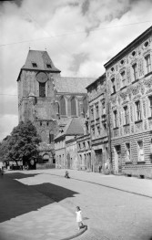 Katedra św. Jana - widoczna wieża i fragment nway głównej. Obok kamienice i ulica., skan 1