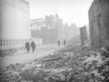 Zniszczona zabudowa miejska. Widok na elewacje frontową Hali Mirowskiej., skan 1