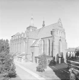 Kościół Wniebowzięcia Najświętszej Maryi Panny - widok ogólny. Elewacja boczna oraz frontowa. Widoczne przypory oraz liczne okna w stylu maswerk. Pinakle na zwieńczeniach skarp. , skan 1