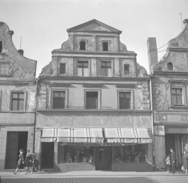 Zabudowa miejska. Elewacja frontowa kamienicy. Renesansowy szczyt. Mieszkańcy. Witryna sklepu odzieżowego. , skan 1